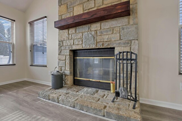 details featuring a fireplace, baseboards, and wood finished floors