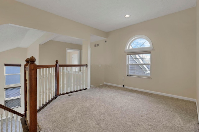 spare room with recessed lighting, carpet flooring, visible vents, baseboards, and vaulted ceiling