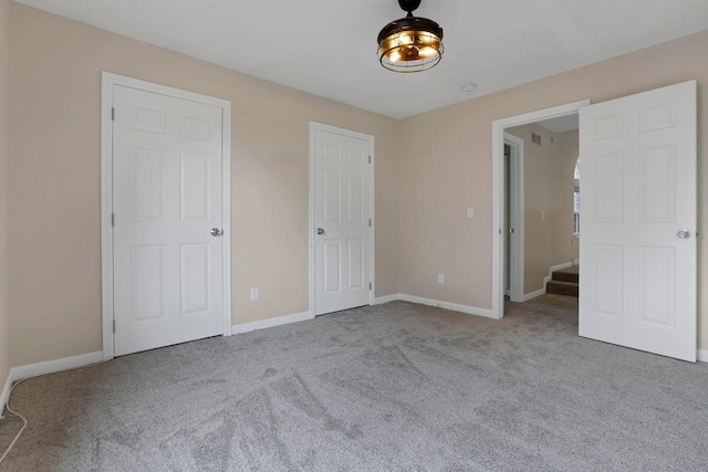 unfurnished bedroom featuring carpet and baseboards