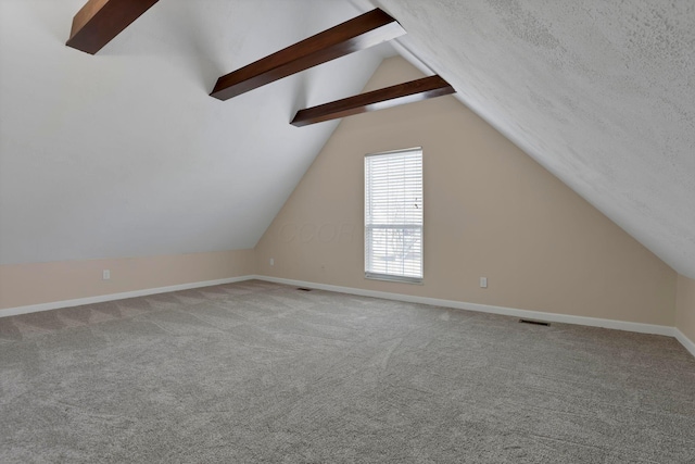 bonus room with baseboards, visible vents, vaulted ceiling with beams, a textured ceiling, and carpet flooring