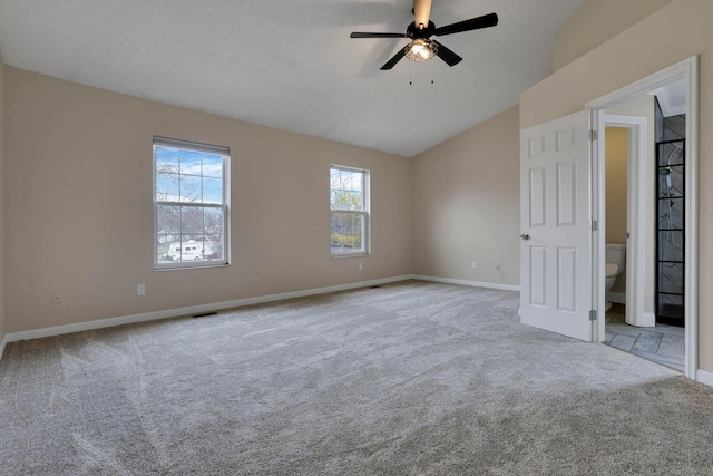 empty room with carpet, vaulted ceiling, baseboards, and ceiling fan