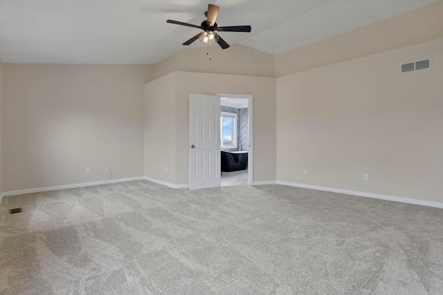 empty room featuring light carpet, baseboards, visible vents, lofted ceiling, and ceiling fan