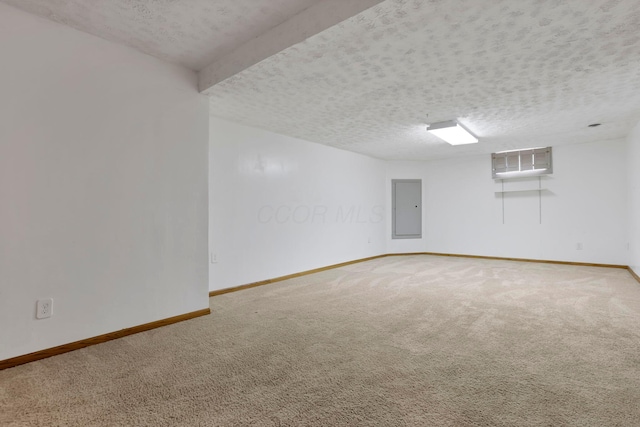 carpeted spare room featuring electric panel, a textured ceiling, and baseboards