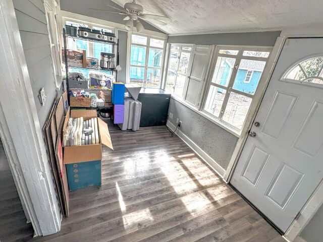 sunroom / solarium with ceiling fan and vaulted ceiling