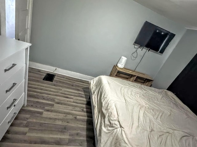 bedroom with dark wood-type flooring