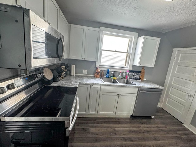 kitchen featuring sink, a textured ceiling, appliances with stainless steel finishes, dark hardwood / wood-style flooring, and white cabinets