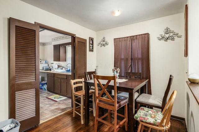 dining room with sink and dark hardwood / wood-style flooring