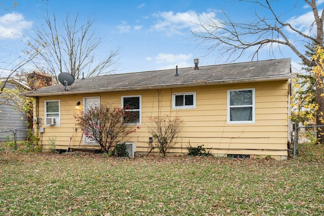 rear view of house with a yard and central AC unit