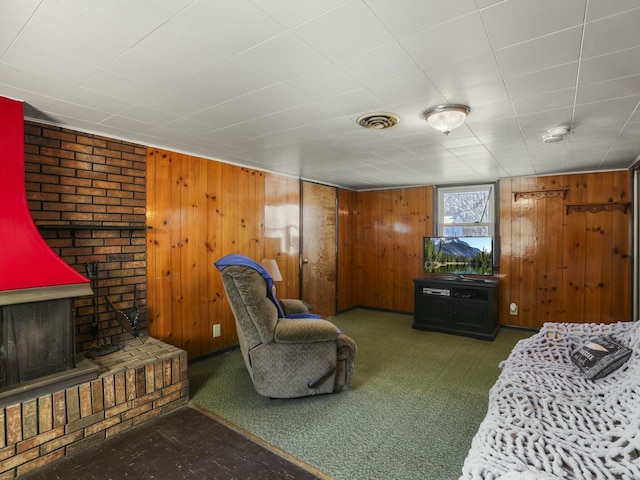 living room with dark colored carpet and wood walls