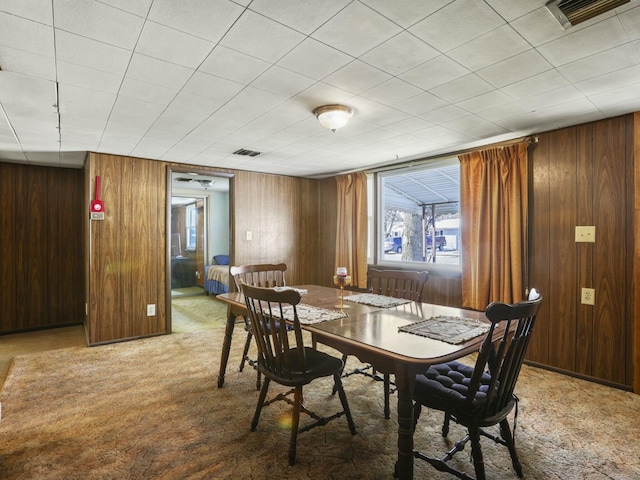 dining area with wooden walls and carpet floors