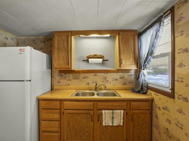 kitchen featuring white refrigerator and sink