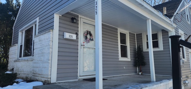 view of snowy exterior featuring covered porch