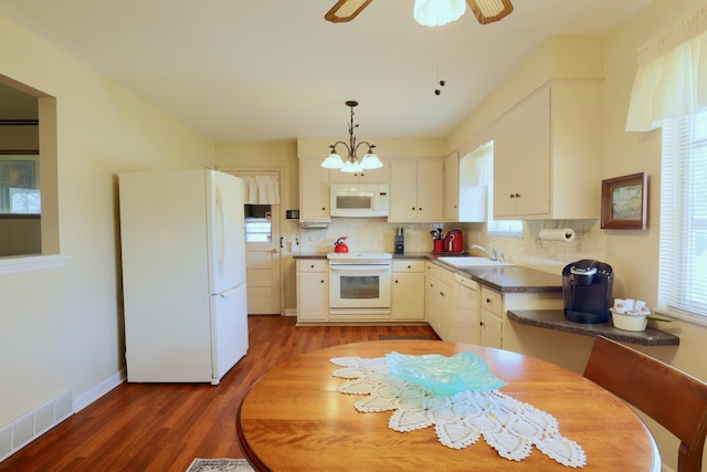 kitchen with sink, white cabinets, backsplash, dark wood-type flooring, and white appliances