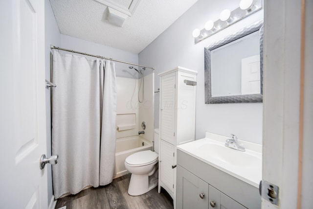 full bathroom with hardwood / wood-style flooring, shower / tub combo, vanity, a textured ceiling, and toilet