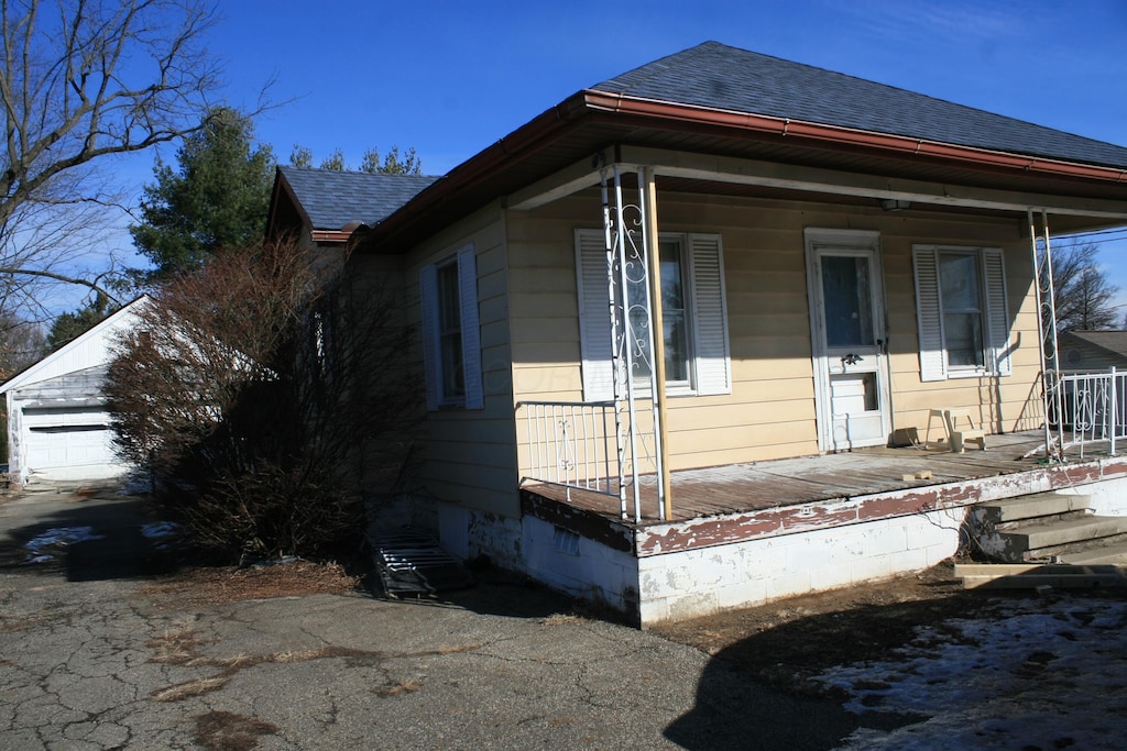 view of side of property with a garage and covered porch