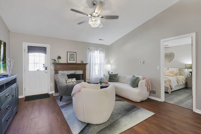 living room with a healthy amount of sunlight, dark hardwood / wood-style floors, and vaulted ceiling