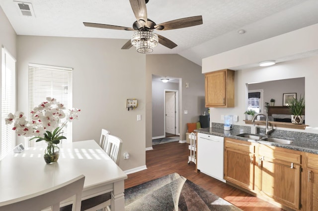 kitchen featuring dishwasher, lofted ceiling, sink, dark stone countertops, and dark wood-type flooring