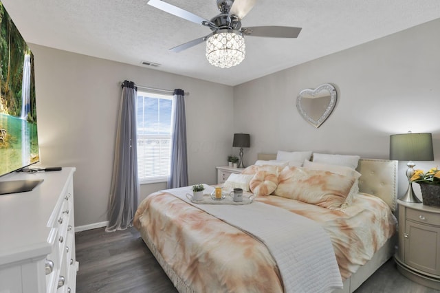 bedroom with ceiling fan, dark hardwood / wood-style floors, and a textured ceiling