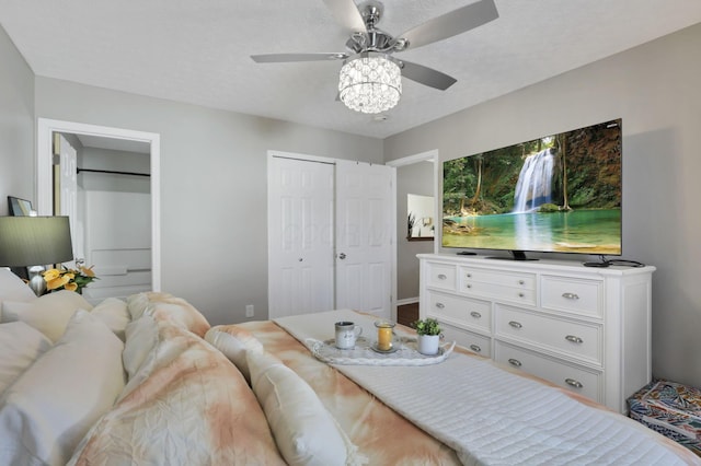 bedroom featuring ceiling fan, a textured ceiling, and multiple closets