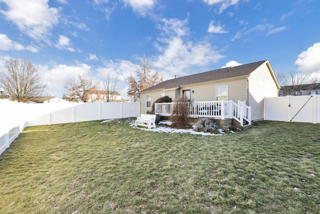 rear view of house with a yard and a deck