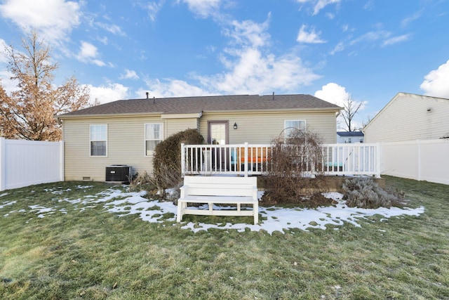 snow covered property with a wooden deck, a yard, and central AC