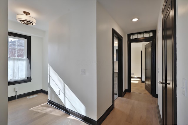 hallway with light hardwood / wood-style floors