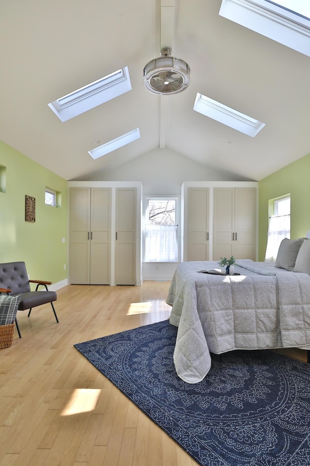 bedroom with light hardwood / wood-style flooring and vaulted ceiling with skylight