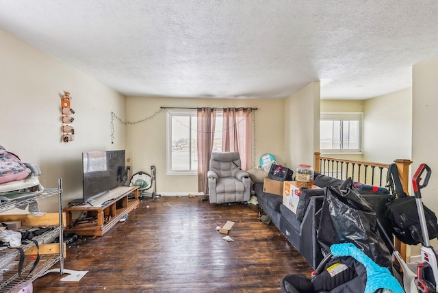 living room featuring plenty of natural light, dark hardwood / wood-style floors, and a textured ceiling