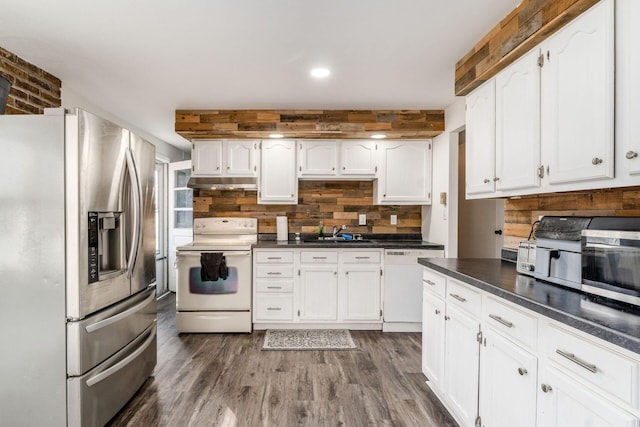 kitchen with sink, appliances with stainless steel finishes, dark hardwood / wood-style flooring, decorative backsplash, and white cabinets