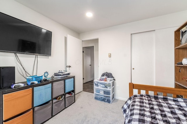 bedroom with light carpet and a closet