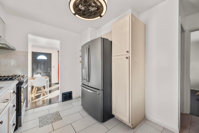 kitchen with backsplash, stainless steel appliances, and light tile patterned floors