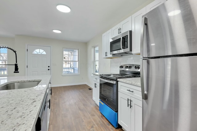 kitchen featuring light stone countertops, appliances with stainless steel finishes, and white cabinets