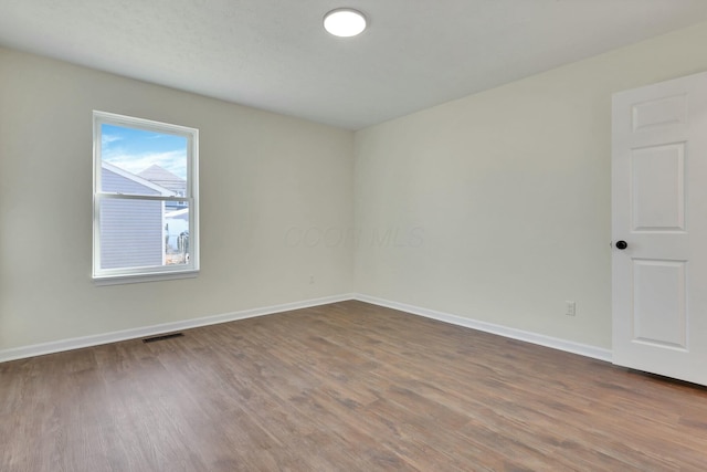 unfurnished room with hardwood / wood-style flooring