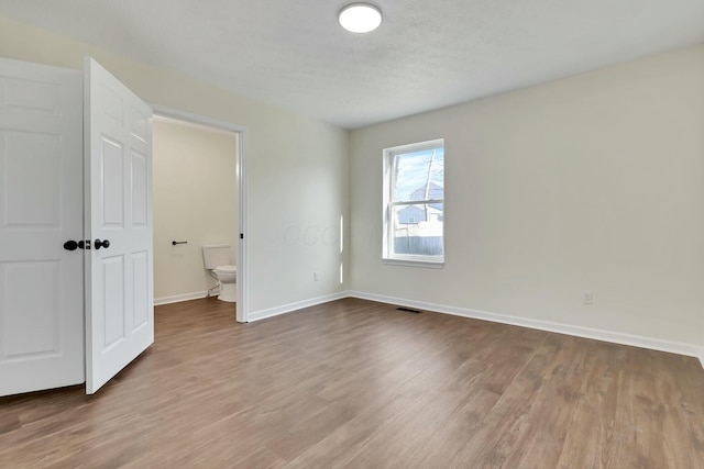 unfurnished bedroom with hardwood / wood-style flooring and a textured ceiling