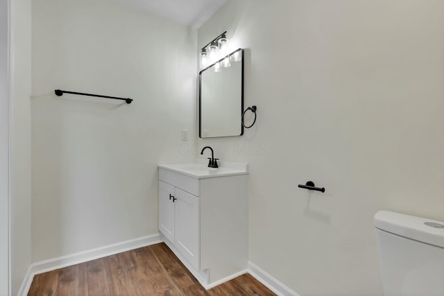 bathroom with vanity, wood-type flooring, and toilet