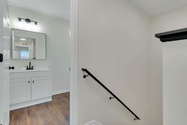 staircase with sink and hardwood / wood-style floors