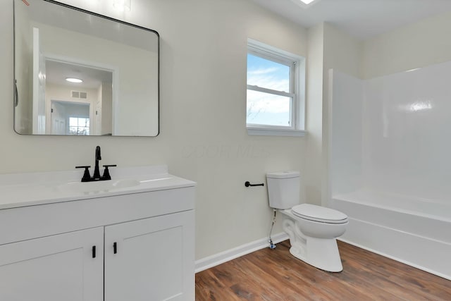 full bathroom with wood-type flooring, vanity, shower / bathtub combination, and toilet