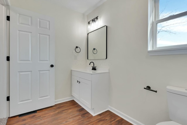 bathroom with vanity, wood-type flooring, and toilet