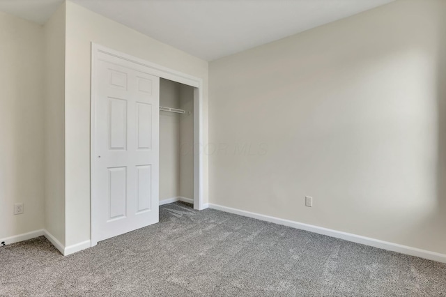 unfurnished bedroom featuring carpet and a closet