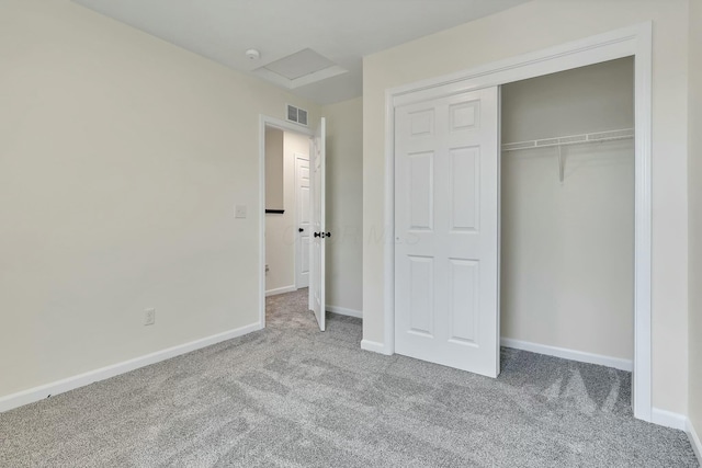 unfurnished bedroom featuring light colored carpet and a closet