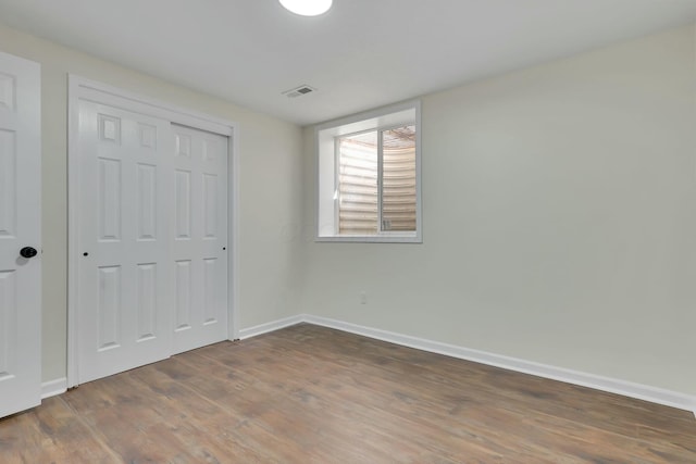 unfurnished bedroom with a closet and dark hardwood / wood-style floors