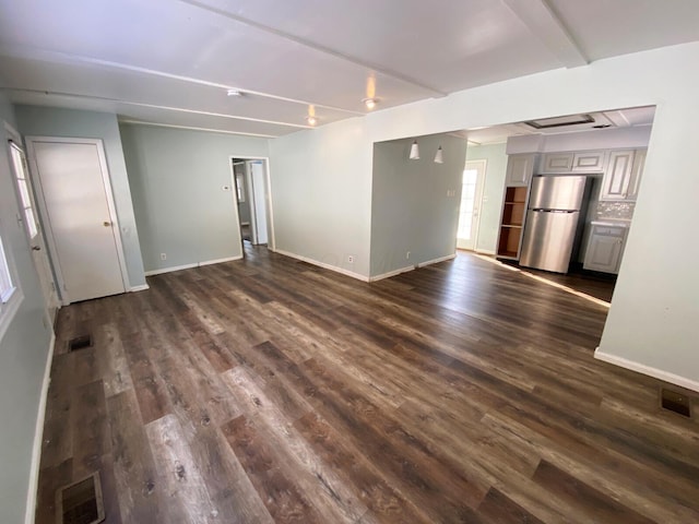 unfurnished living room with dark hardwood / wood-style flooring and beam ceiling