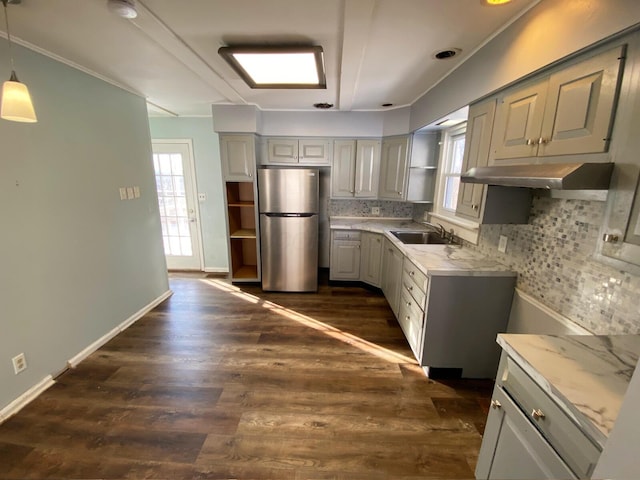 kitchen with pendant lighting, sink, stainless steel refrigerator, gray cabinetry, and a wealth of natural light