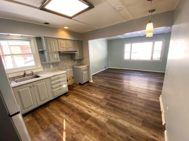 kitchen featuring decorative backsplash, dark hardwood / wood-style floors, sink, and hanging light fixtures