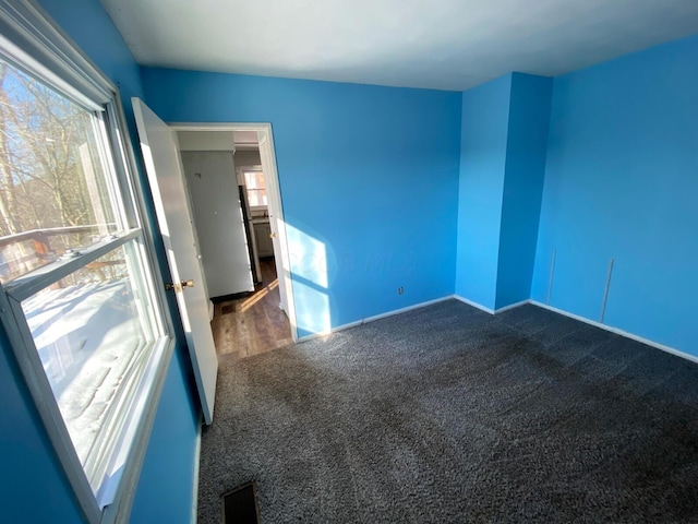 empty room featuring dark carpet