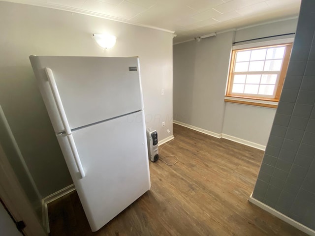 kitchen with white refrigerator, ornamental molding, and wood-type flooring