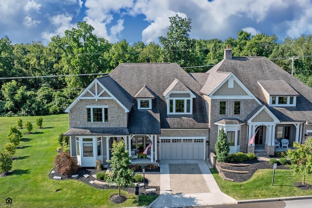 craftsman house featuring a garage, a front lawn, and covered porch