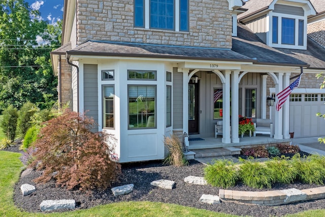 view of exterior entry featuring a porch and a garage