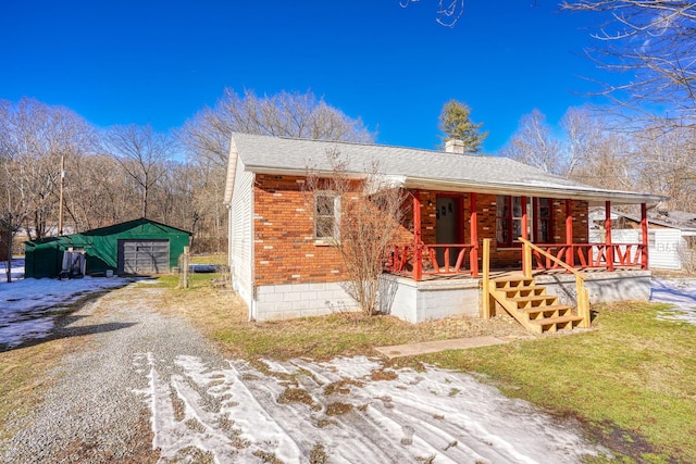 view of front of property with a garage, an outdoor structure, and a porch