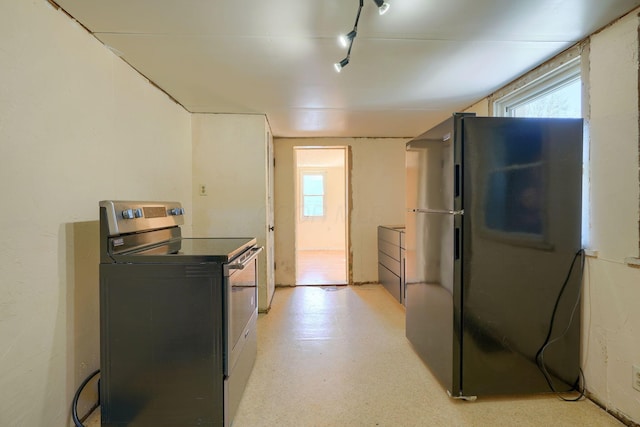 kitchen with stainless steel range with electric stovetop, washer / clothes dryer, and black fridge